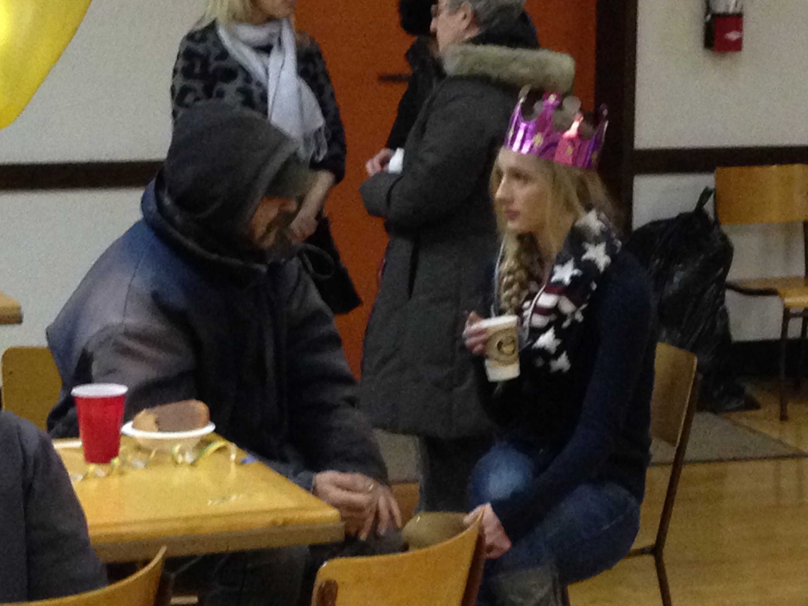 A young woman and hungry person converse in a church hall